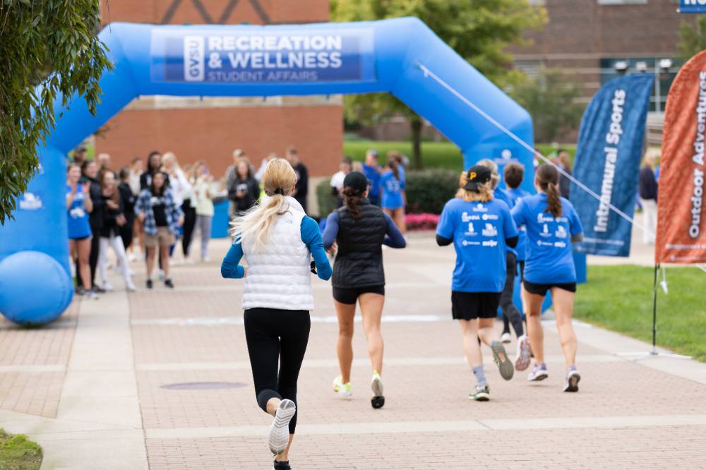 Participants nearing finish line showing blue arch
